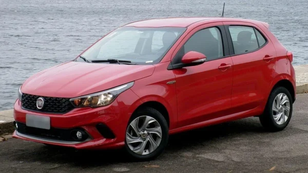 Fiat Argo Drive vermelho visto de frente e de lado, estacionado próximo à orla
