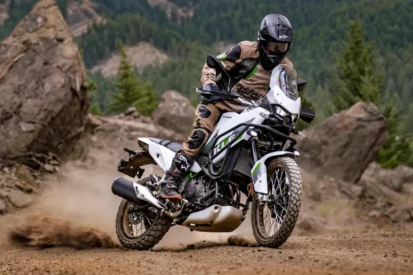Kawasaki KLE 650 2027 cinza e verde sendo pilotada em estrada de terra.